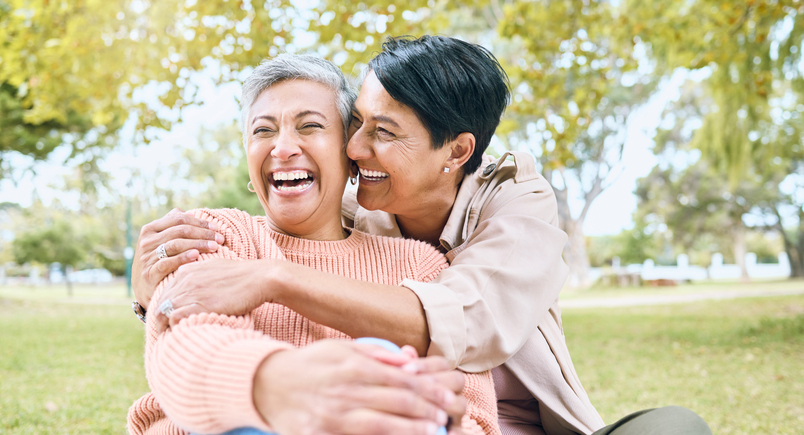 Couple of friends, seniors or laughing hug in nature park, grass garden or relax environment in comic, funny or silly activity